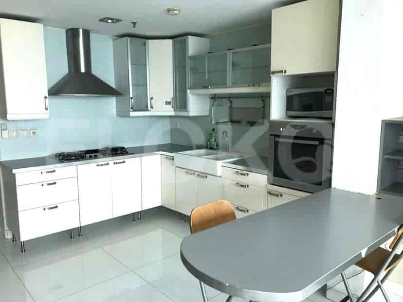 Modern kitchen with white cabinets, appliances, and a small dining table.