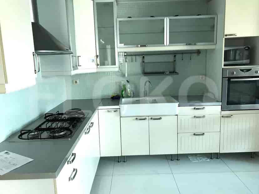 Modern kitchen with white cabinets, appliances, and a small dining table.