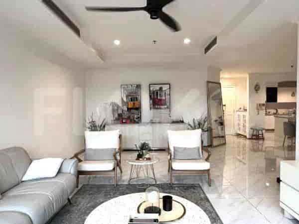 A modern living room with a grey sofa, two white chairs, and artwork.