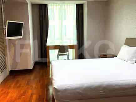 Bedroom with a bed, a desk, and a large window.