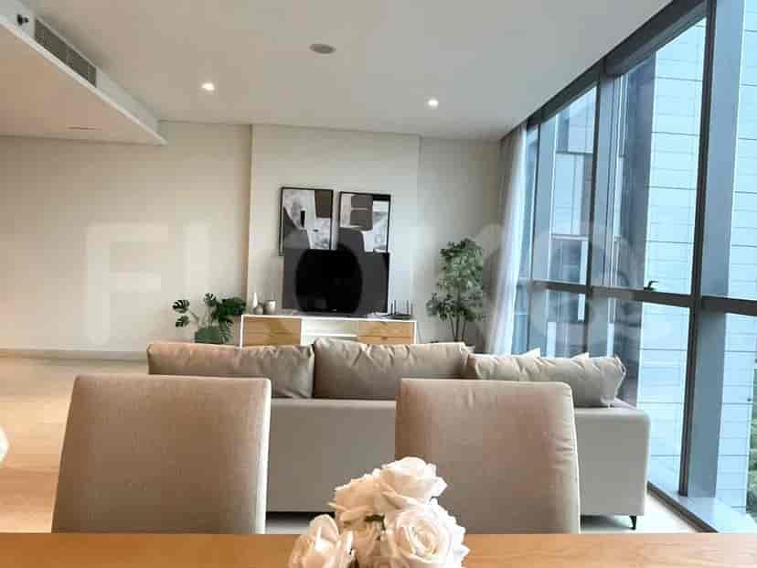 Living room showing a sofa, TV, and large windows with a city view.