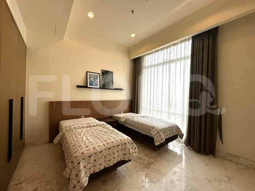 Twin beds in a bedroom with large windows and closet.