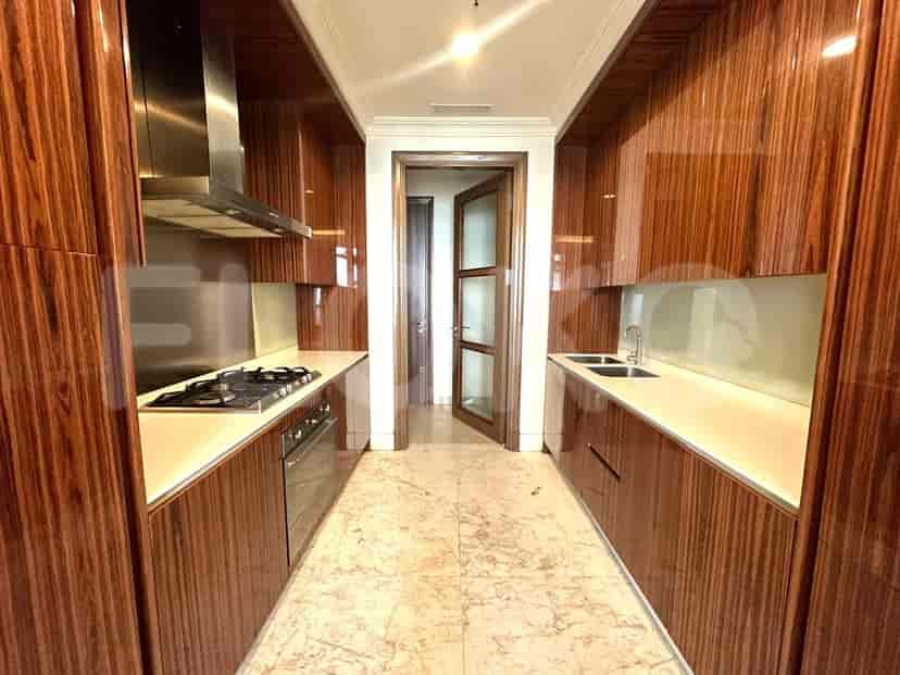 A kitchen with wooden cabinets, stainless steel appliances, and marble flooring.