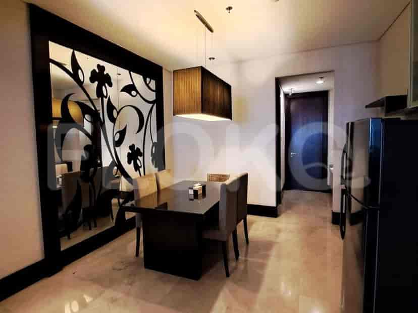 The dining area with a modern dining table and a decorative mirror.