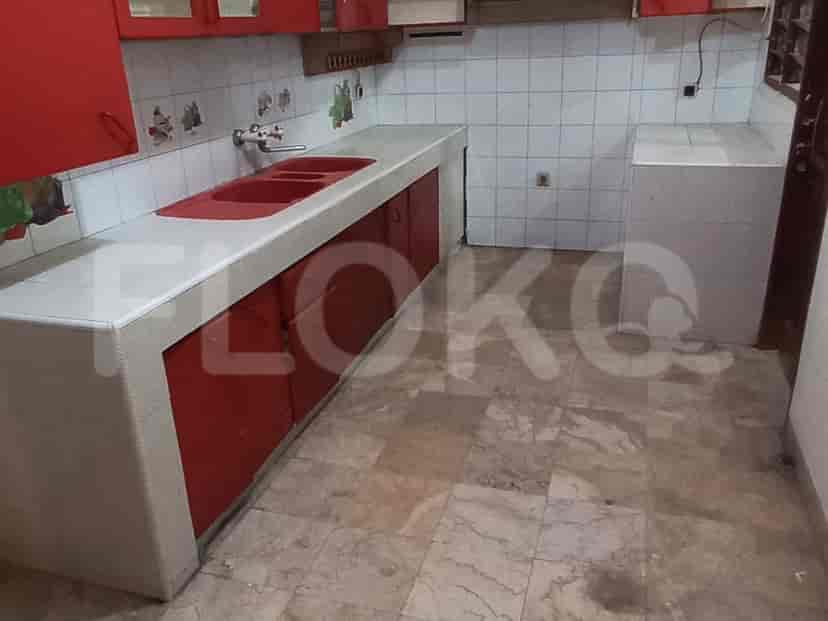 A kitchen with red cabinets and white countertops.
