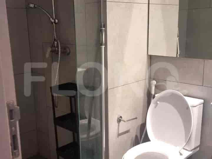 A small bathroom with a shower and toilet.