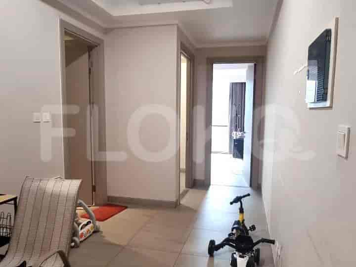 A hallway with doorways, a red rug, and a small toy vehicle.