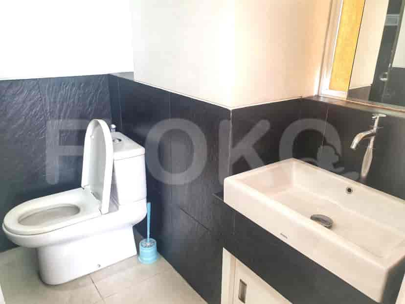 Modern bathroom with a toilet, sink, and tiled walls.