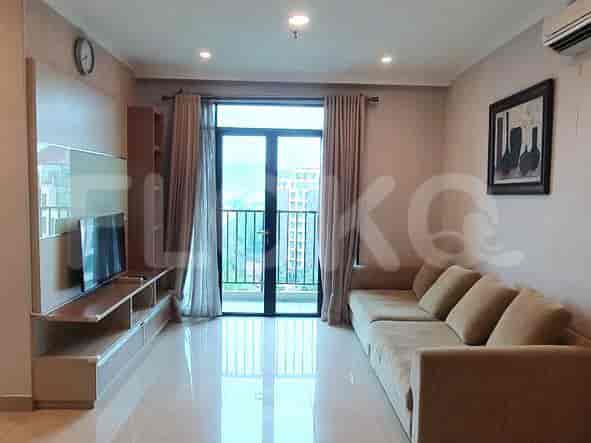 Spacious living room with an L-shaped beige sofa, a wall-mounted TV, and a large window.