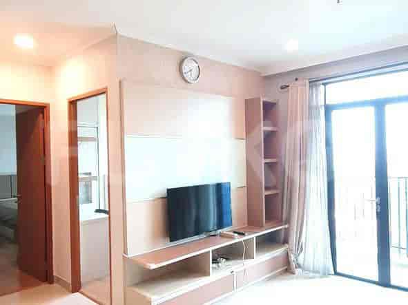 A close-up view of the entertainment unit with the TV, clock, and balcony access.