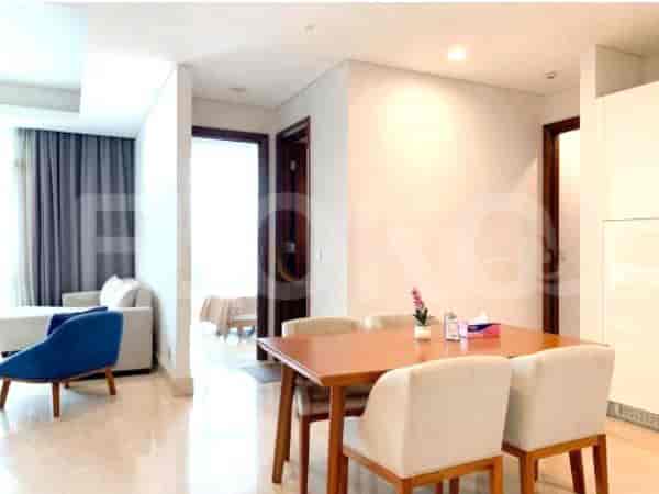 A modern dining room with a table, chairs, and an adjacent living area.