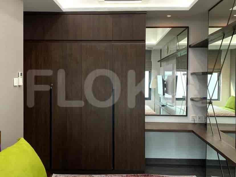 Walk-in closet dengan pintu kayu gelap dan cermin panjang.