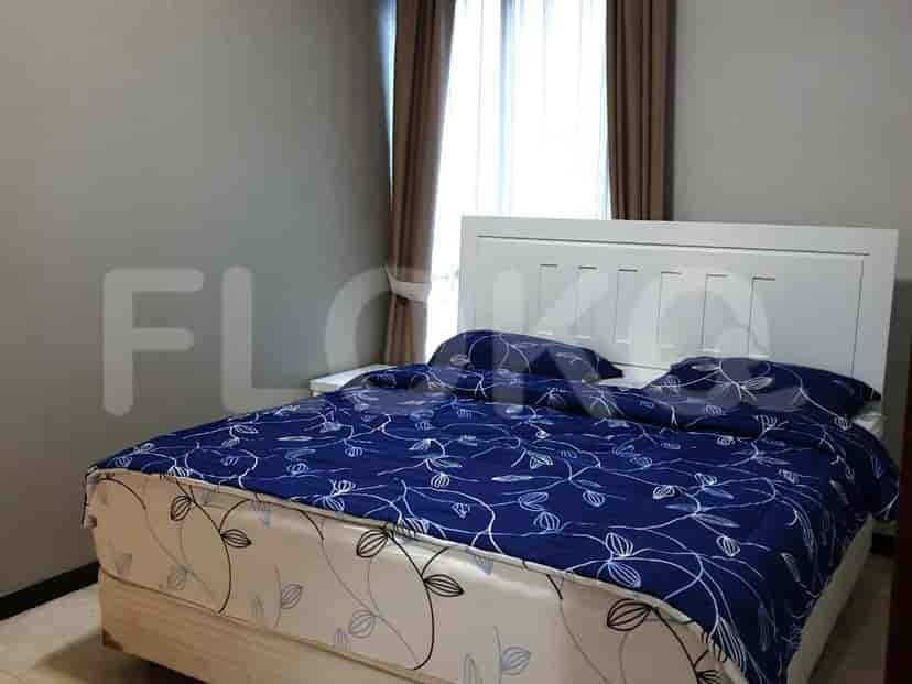 A bedroom with a queen-size bed and a large window.