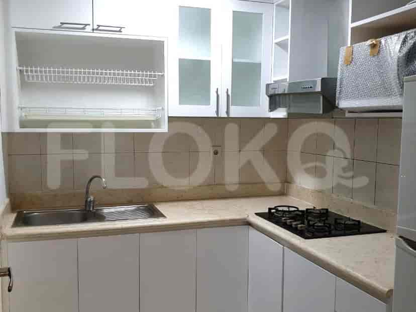 A compact kitchen with white cabinets and a marble countertop.
