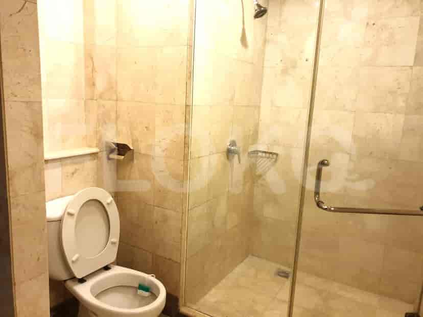 A bathroom with a shower, toilet, and glass enclosure.