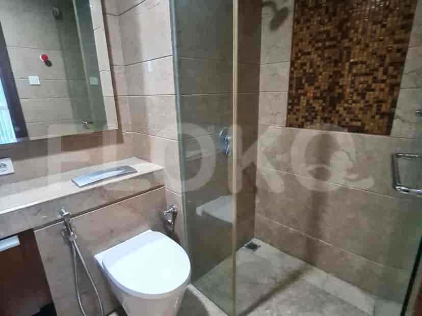 Kamar mandi dengan shower, toilet, dan cermin.