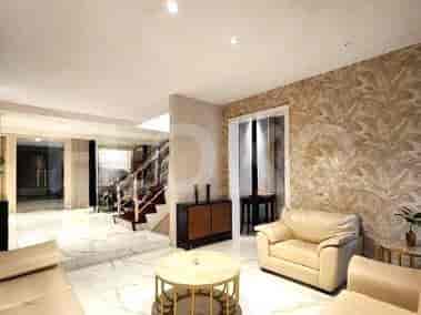 A living room with beige sofas, a round coffee table, and marble flooring.