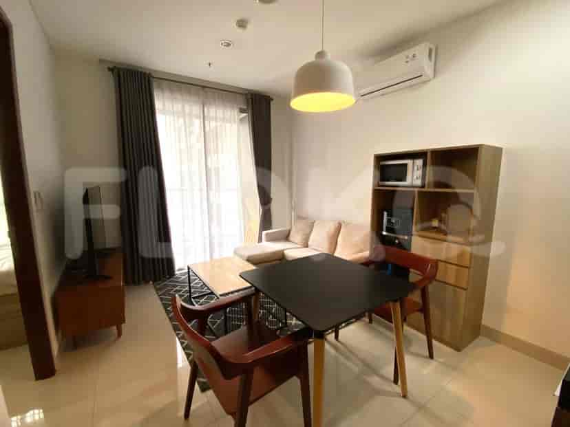 Area gabungan ruang tamu dan ruang makan dengan sofa, meja makan, dan dapur.