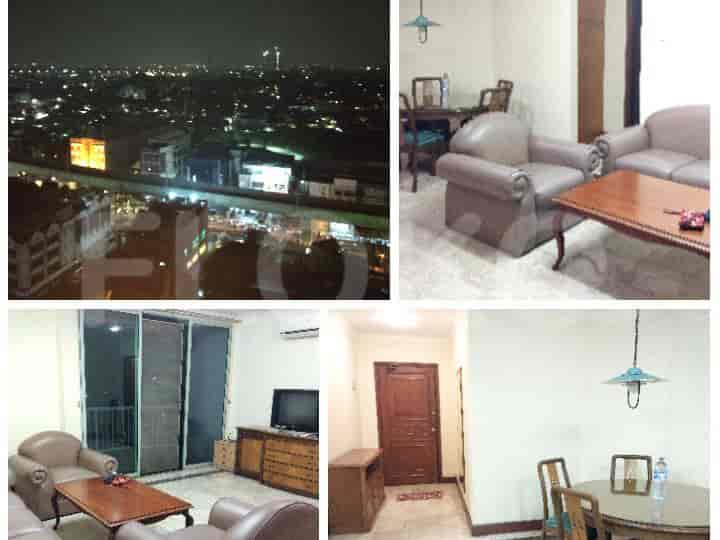 Living room with seating, a table, and a night view of the city.