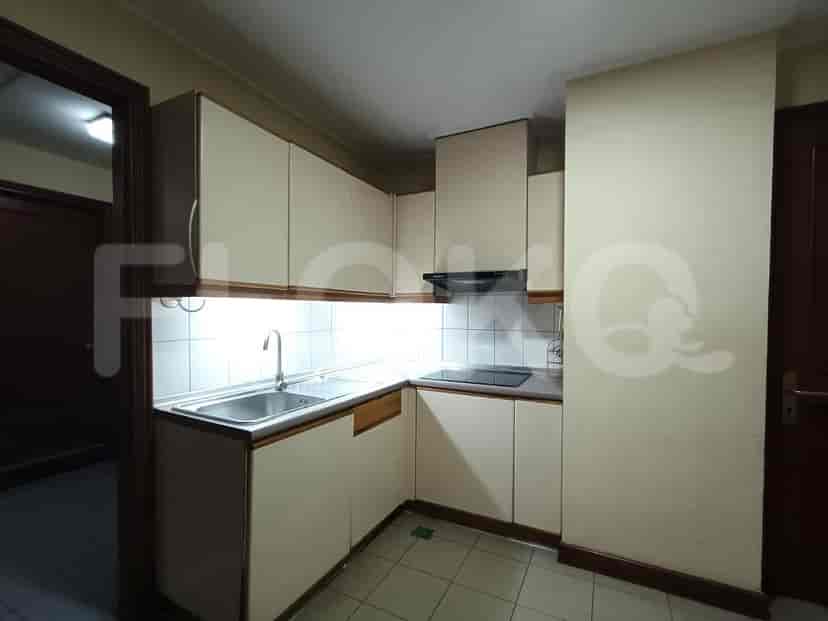 A kitchen with white cabinets, a sink, and an electric stove.
