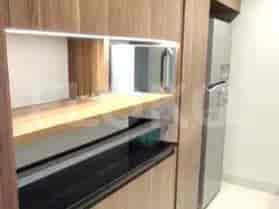 A modern kitchen featuring wooden cabinets, a stainless steel refrigerator, and integrated appliances.