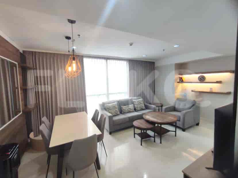 Living area showcasing a sofa, coffee tables, and dining table under ambient lighting.