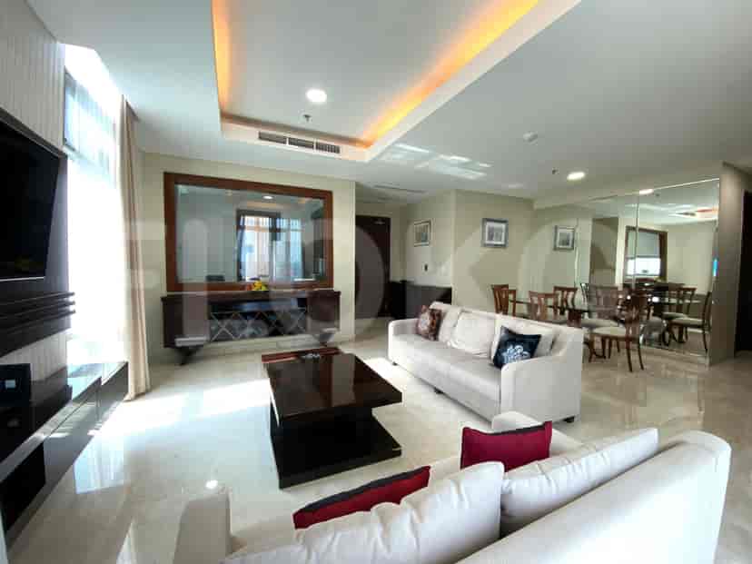 Living room showing a dining area, sofa, large mirror, and TV, with a focus on the space's elegant design.