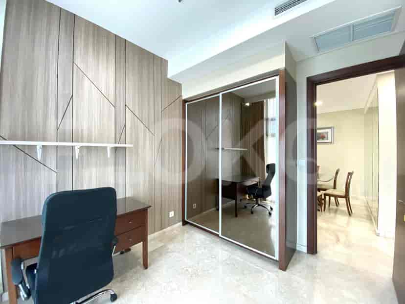 A study room with a desk, a closet, and a wooden panel wall.