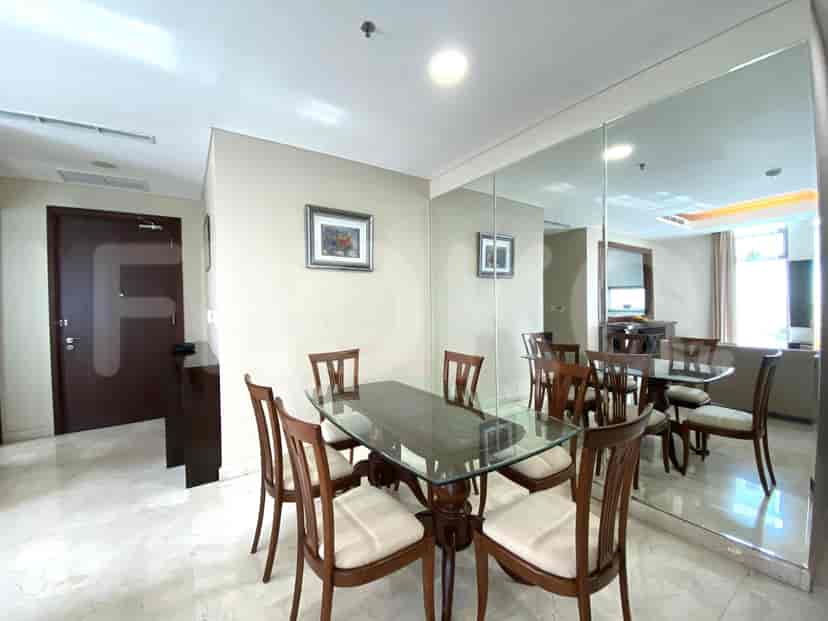 Dining area with a glass table, chairs, and a mirror.