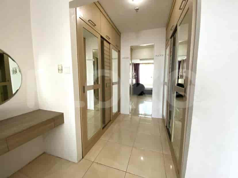 A hallway with built-in closets, a mirror, and a vanity.
