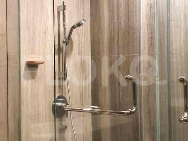 Shower area with a glass door and a hand-held shower.