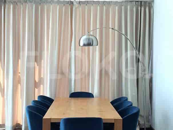 Dining table with blue chairs and beige curtains.
