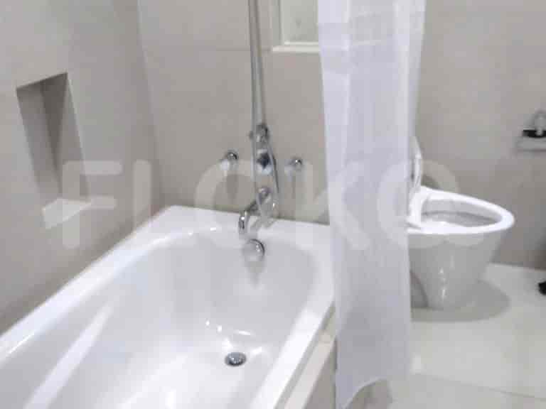 Kamar mandi dengan bak mandi, toilet, dan area pancuran.