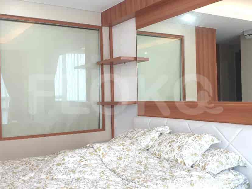 Bedroom with a bed, mirror, and wooden accents.