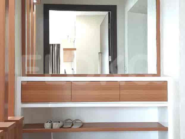 Entryway with shoe rack, mirror, and storage.