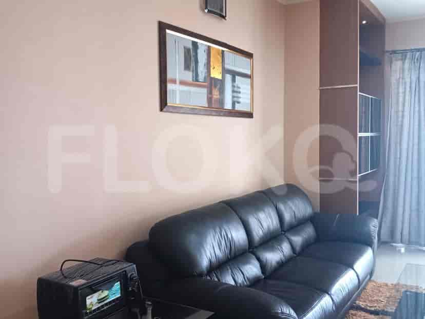 Living room with a black leather sofa and a decorative mirror.