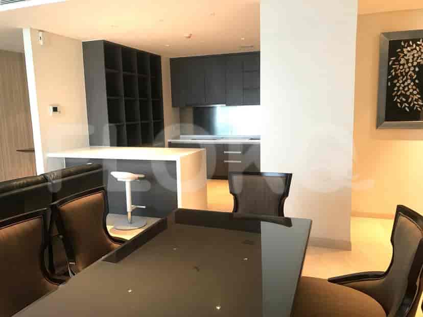 Dining area with table and kitchen area with a bar.