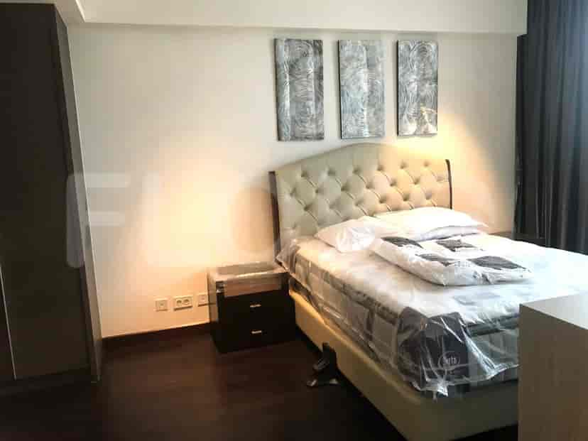 Bedroom with a bed, bedside table, and artwork.