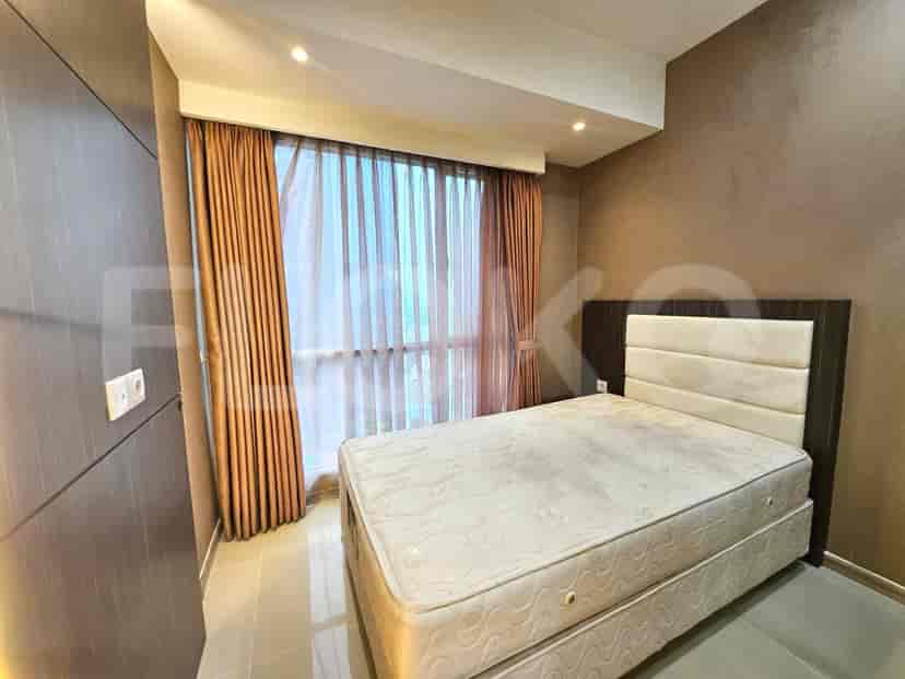 Kamar tidur dengan tempat tidur ukuran queen, jendela besar, dan skema warna coklat dan krem.