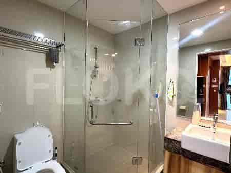 Modern bathroom with a glass shower enclosure, toilet, and sink.
