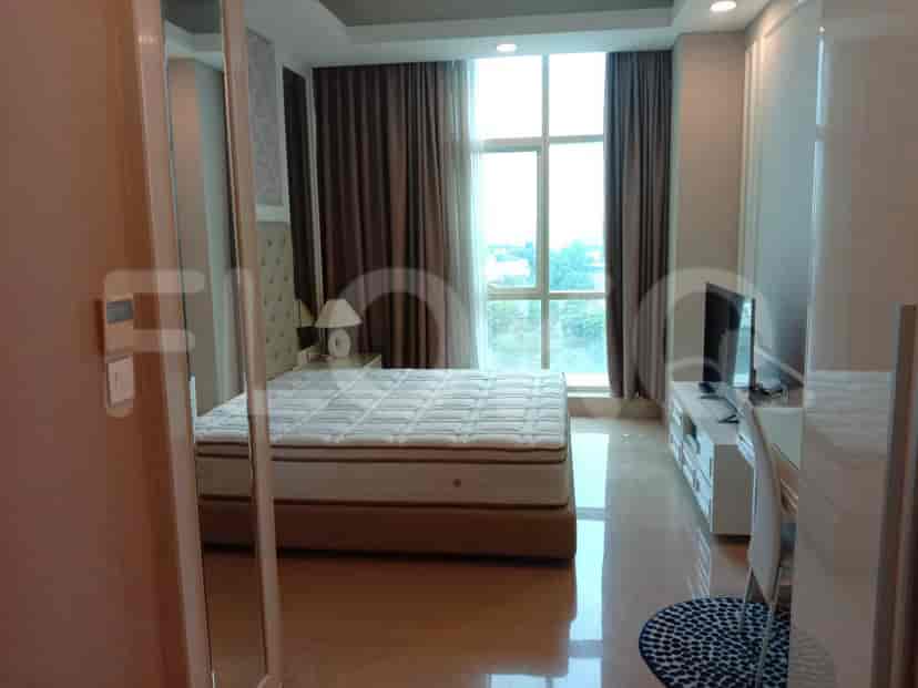 Master bedroom with a king bed, desk and a view to the windows.
