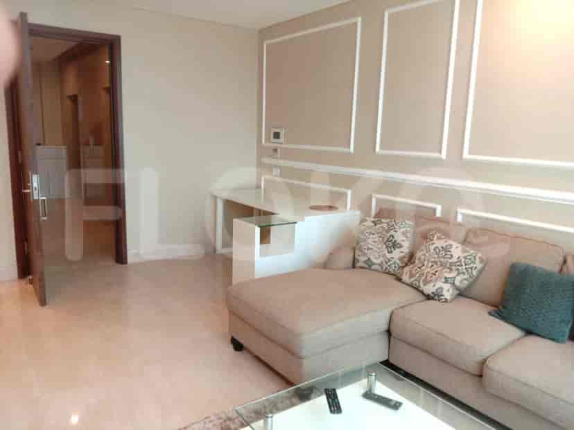 View of the living room showing the sofa, side cabinet, and a glimpse of the hallway.