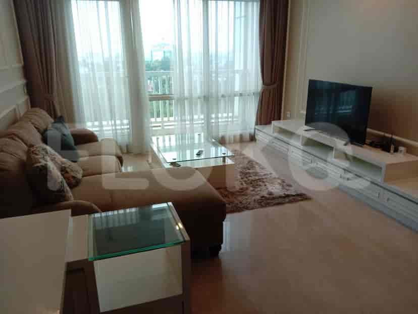 Elegant living room with an L-shaped sofa, glass coffee table, and a wall-mounted TV.