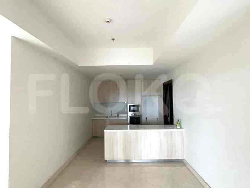 A modern kitchen area, featuring a minimalist design with wooden cabinets and a white countertop.