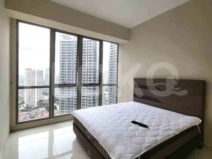 A bedroom with a large window overlooking the city and a queen-sized bed.