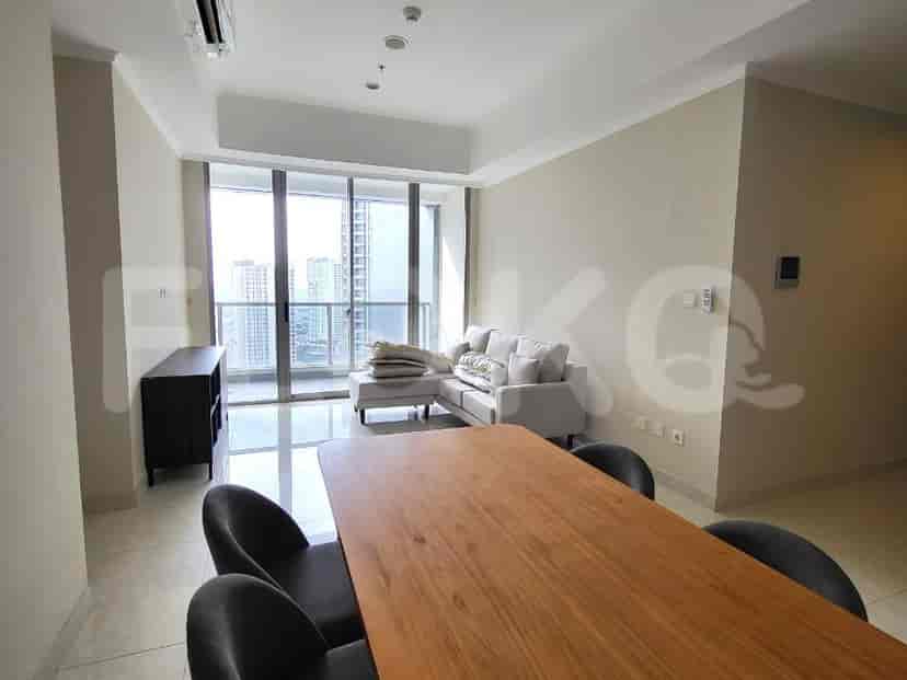 A modern living room with a dining table, sofa, and large windows.