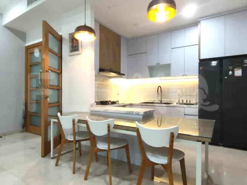 A modern kitchen with a dining table, chairs, and overhead lighting.