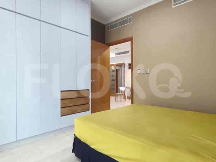 A bedroom with a bed, closet, and a doorway leading to another space.