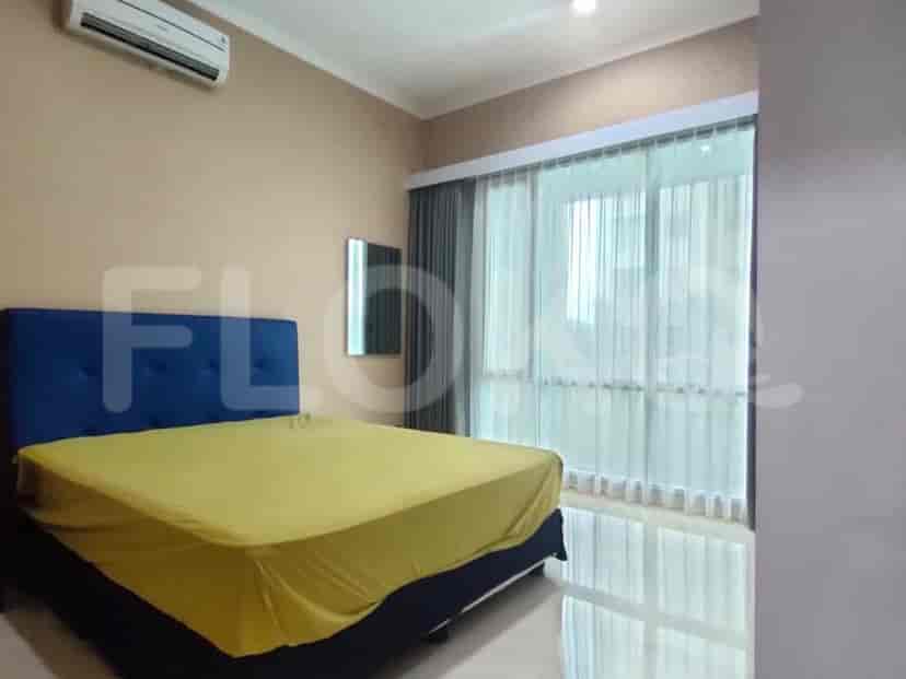 A bedroom with a bed, curtains, and an air conditioning unit.