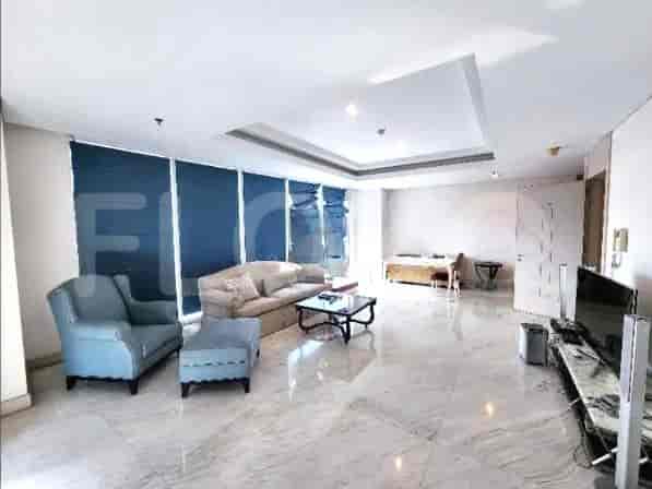 Ruang tamu yang luas dengan kursi berlengan biru, ottoman, sofa, dan jendela besar.